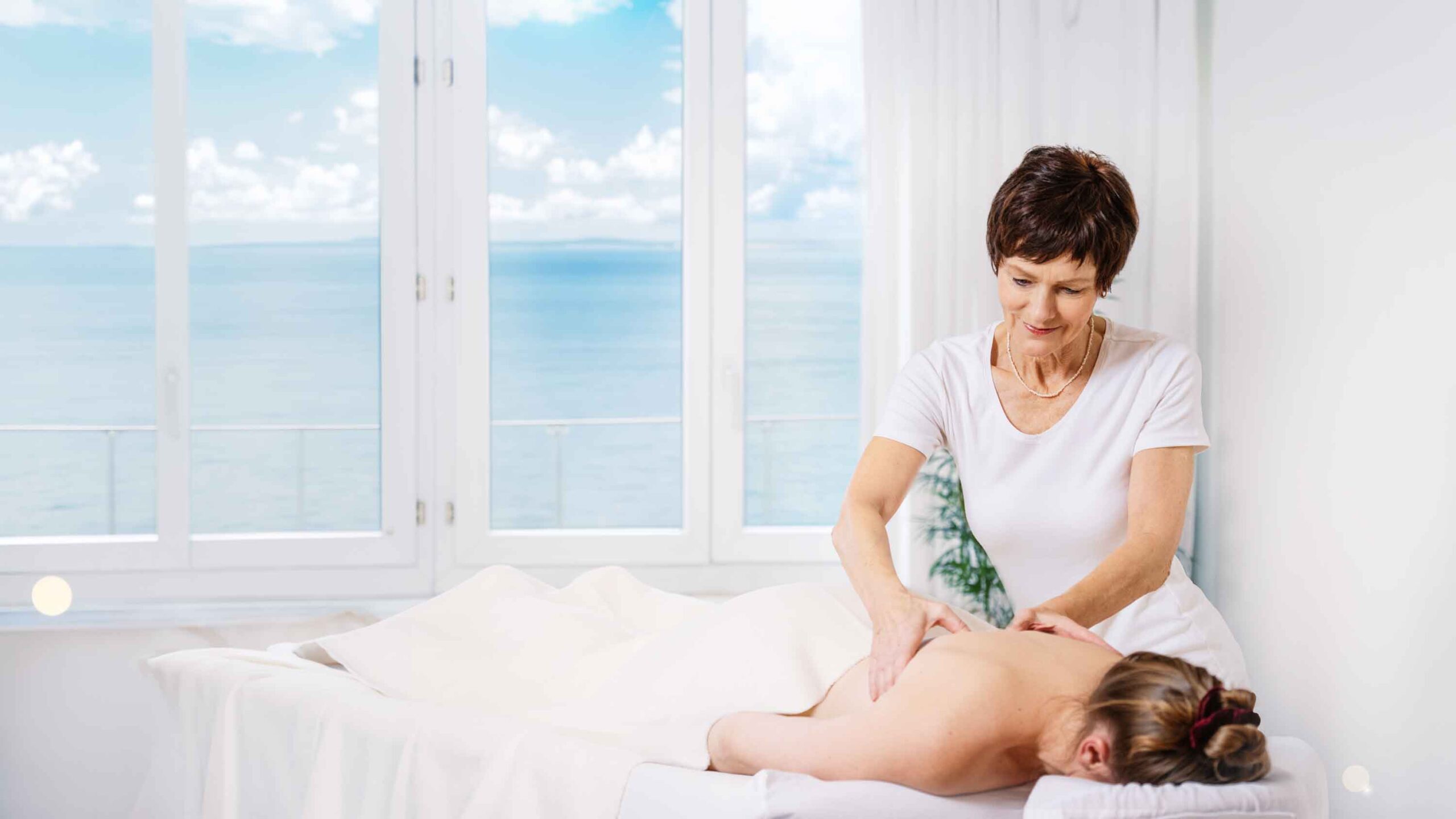 Tibetische Heilmassage in heller Praxis mit Meerblick – sanfte Rückenmassage zur Sommer-Wohlfühlmassage nach Tibetischer Heilkunst